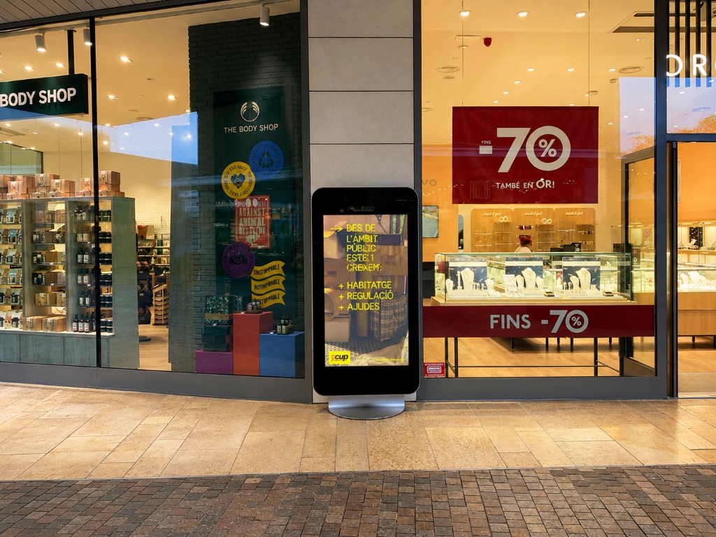 Totem digital en galeria comercial davant The Body Shop
