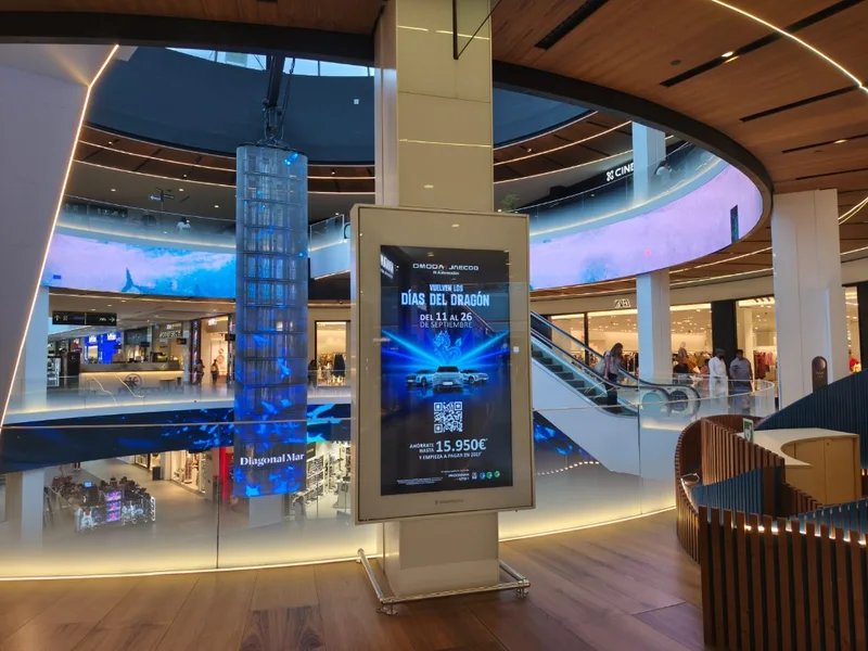 Tótem digital publicitario y pantalla cilíndrica en el atrio central del centro comercial Diagonal Mar