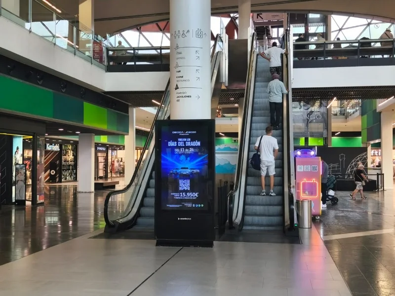 Pantalla digital de publicitat al costat de les escales mecàniques a Màgic Badalona