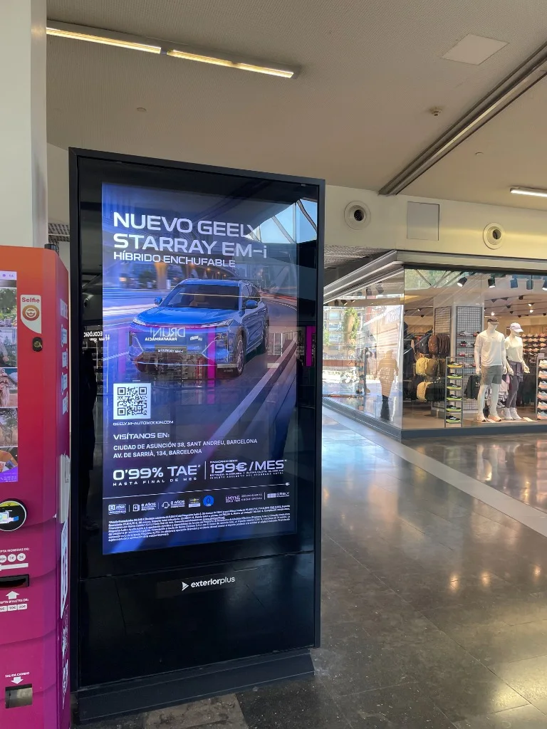 Tótem digital de publicidad en zona de perfumería y tiendas de un centro comercial